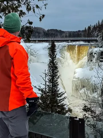 A man gazes out over a roaring Kakabeka Falls during winter in Thunder Bay