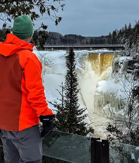 A man gazes out over a roaring Kakabeka Falls during winter in Thunder Bay