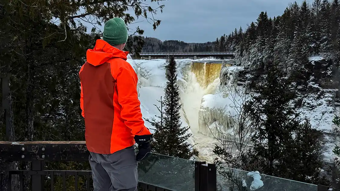 A man gazes out over a roaring Kakabeka Falls during winter in Thunder Bay