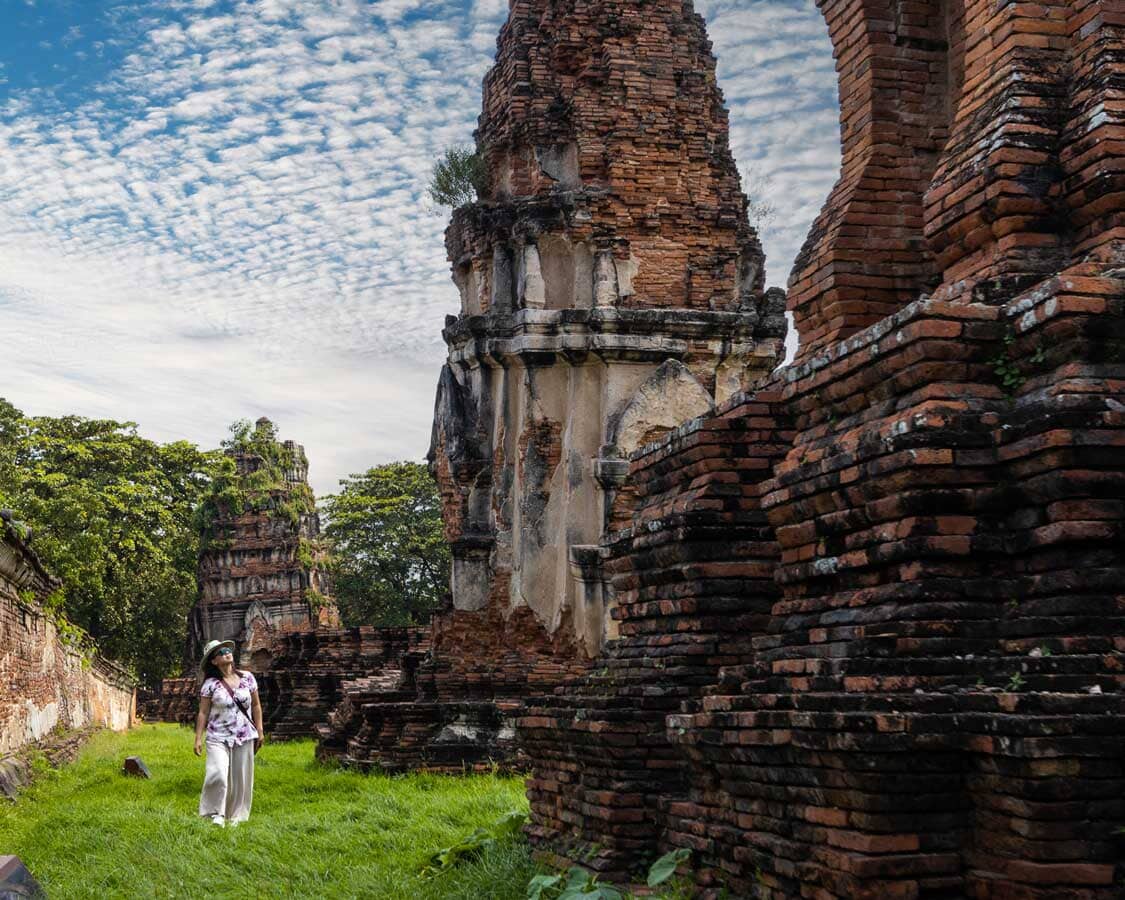Woman walking through Wat Chaiwatthanaram in Ayutthaya Thailand