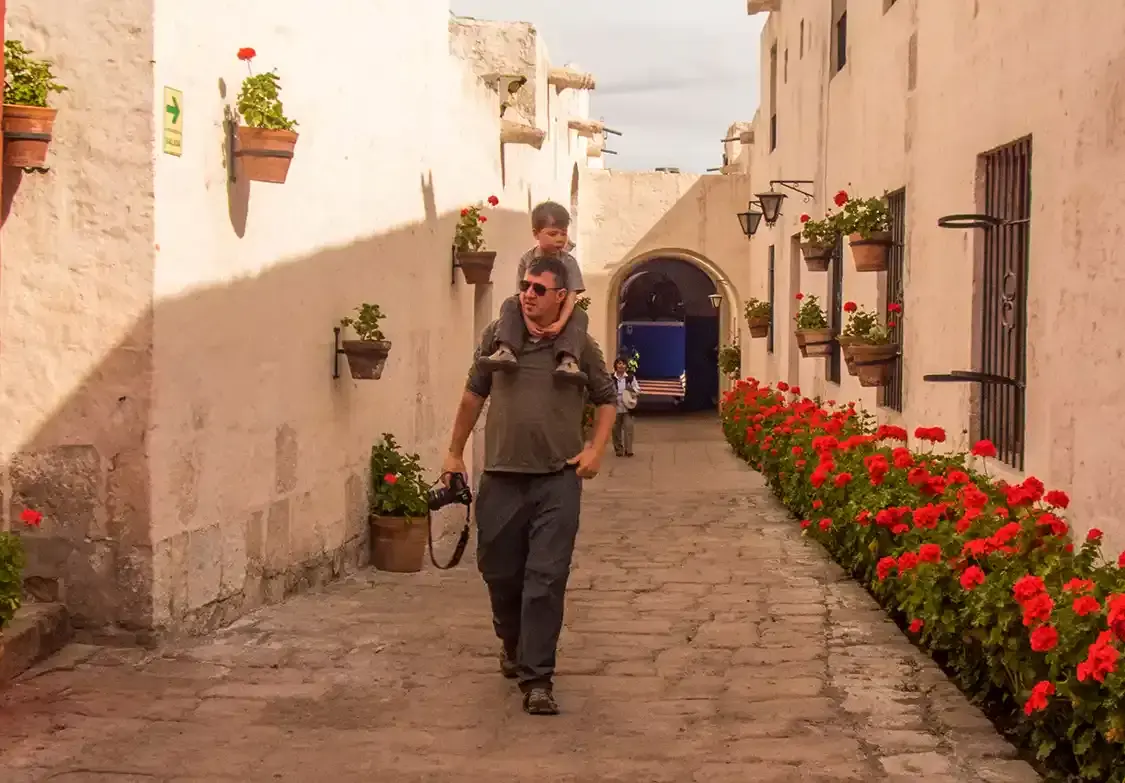 A father piggybacks his toddler in Arequipa