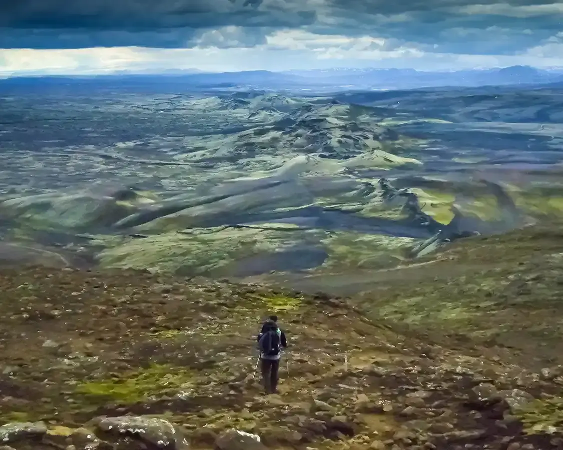 A man carrying his baby hikes through the rift valley of central Iceland