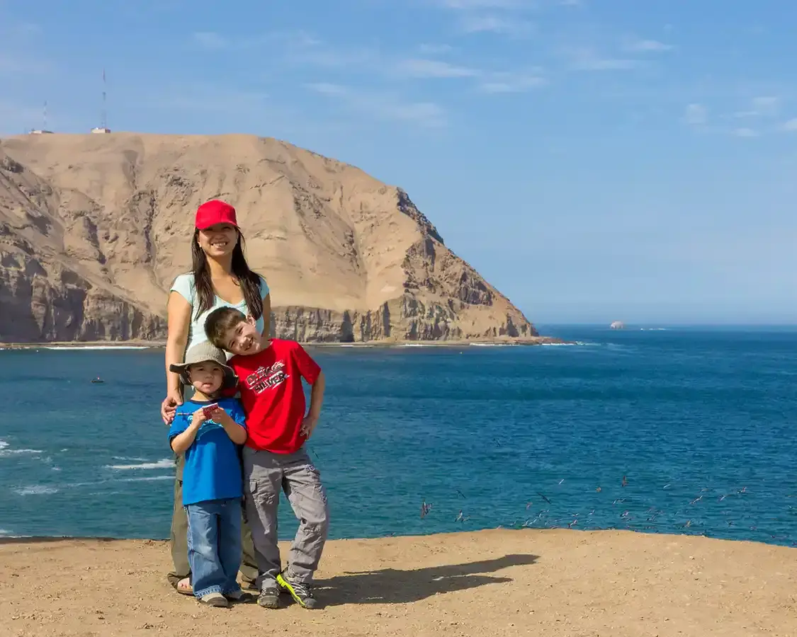 A woman and her two children walking along the coast of Lima Peru