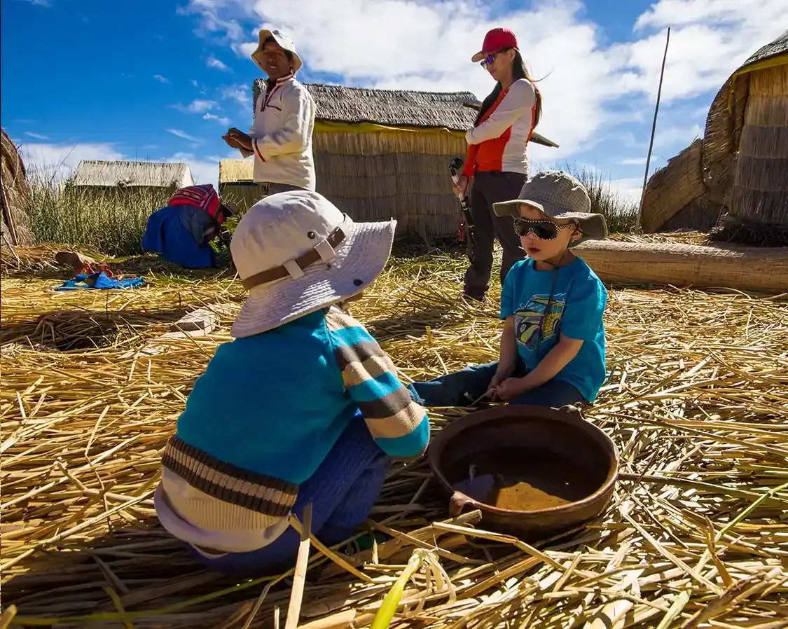A young Canadian boy and a young Uros boy play on Lake Titicaca