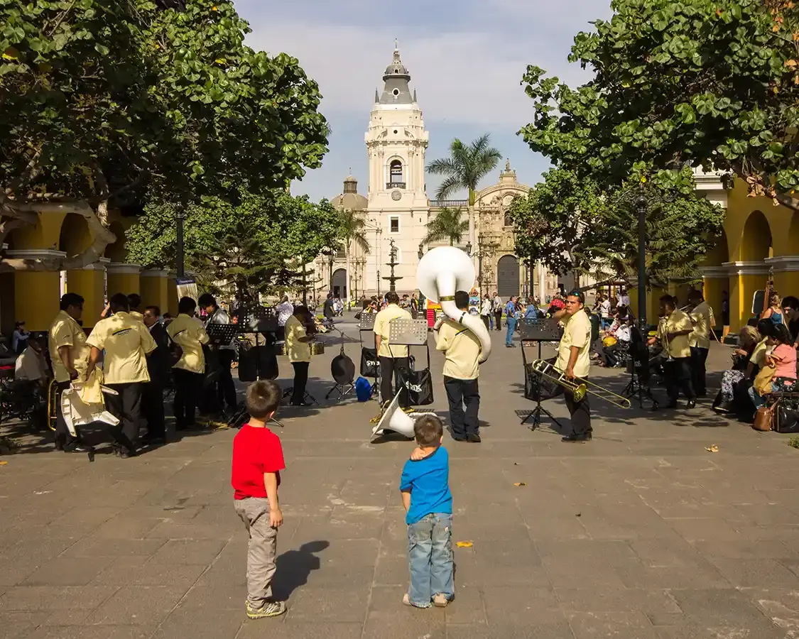 Children watch a band perform on the streets of Lima Peru