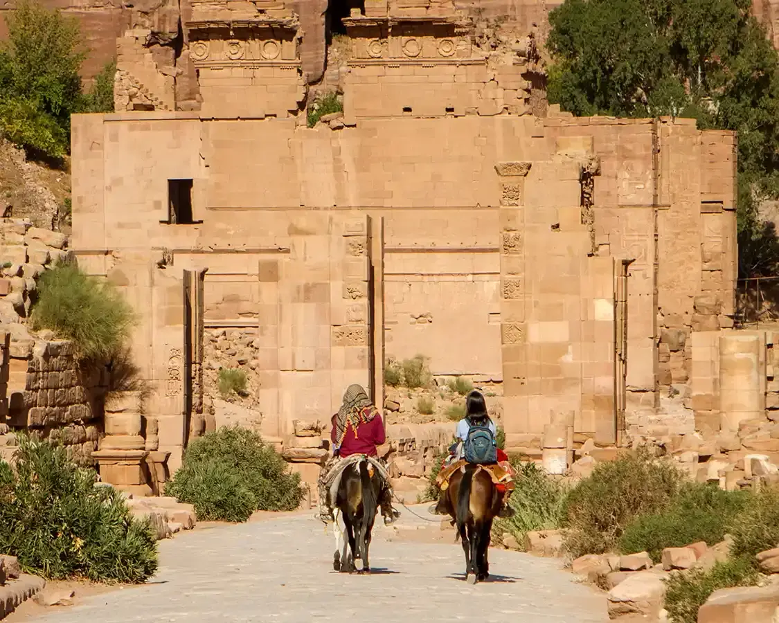 Family riding horseback through Petra Jordan