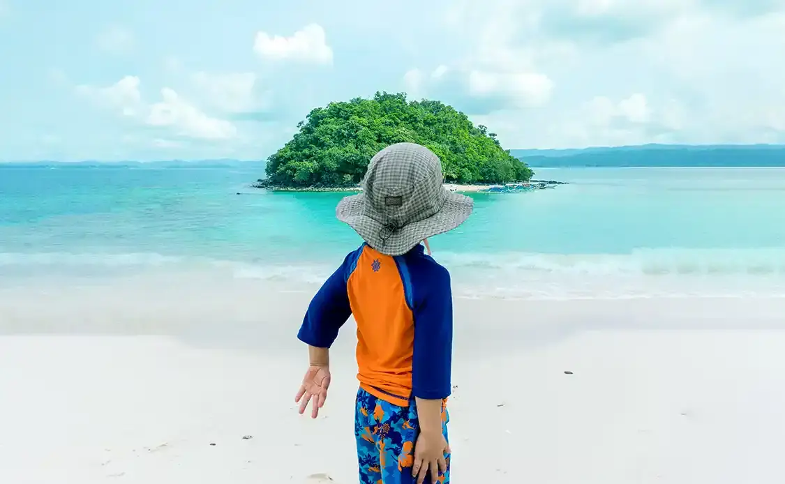 A young boy look out at an island in San Vicente Philippines