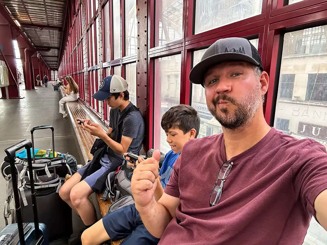 Father laughs at his two teenagers on their phones in Antwerp Belgium