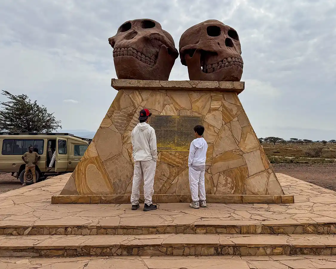 Boys reading a plaque at Olduvai Gorge Tanzania