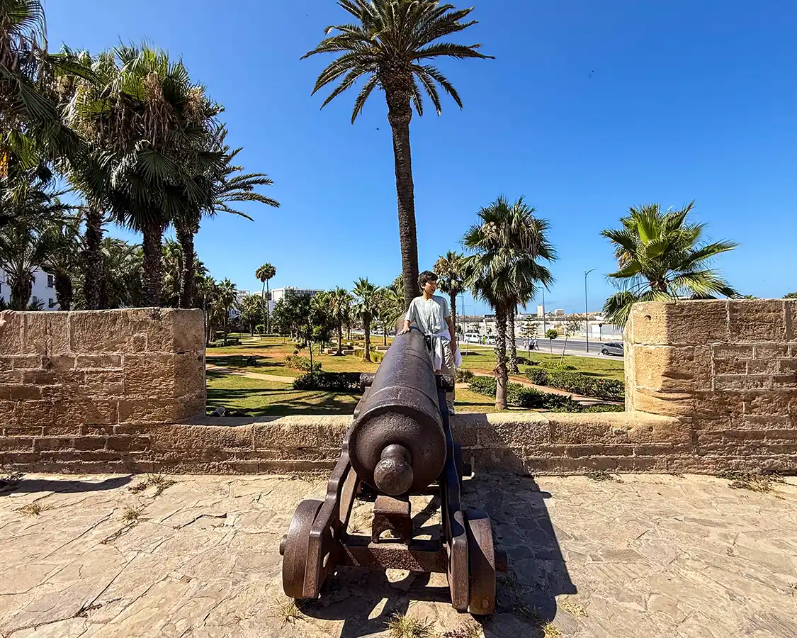 Child stands with a canon a the La Sqala Fortress