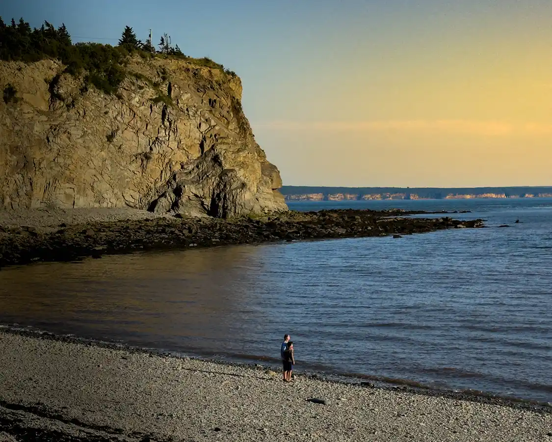 Kevin Wagar and his son watch the sunset from Cape Enrage beach near Moncton
