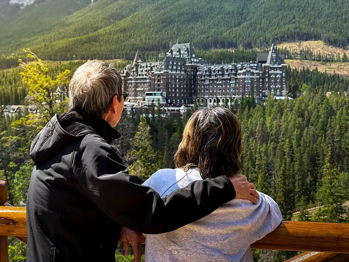 An older couple enjoys the lookout at Surprise Corner in Banff