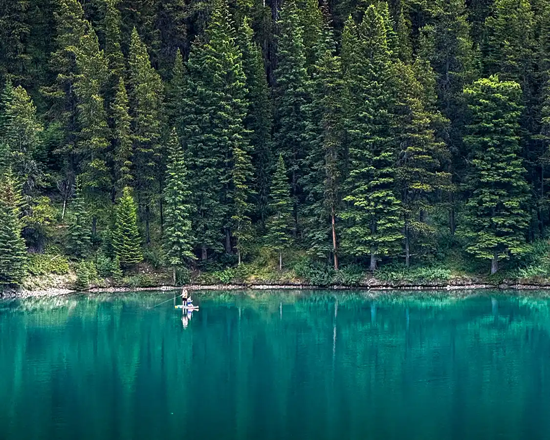Man fishing from a paddle board on Lake Minnewanka