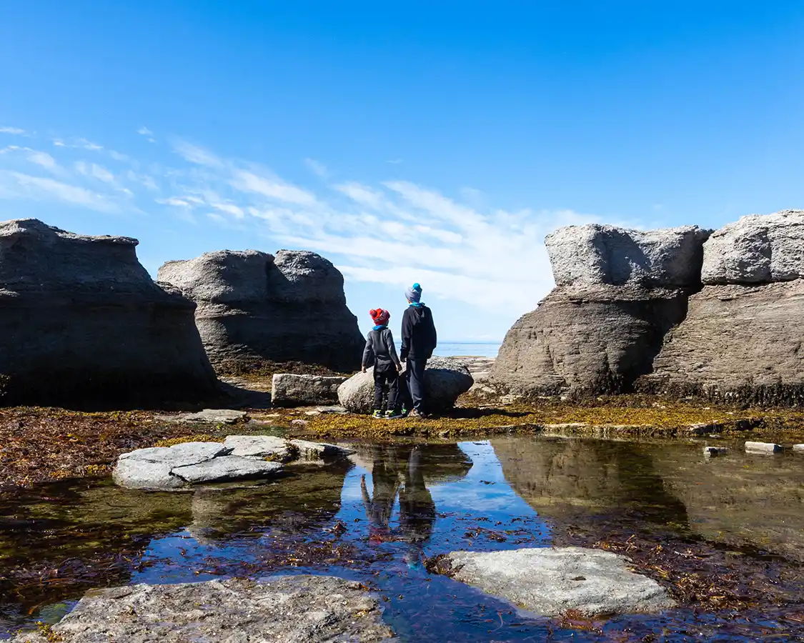 Two boys hiking through Ile Nue de Mingan rock formations