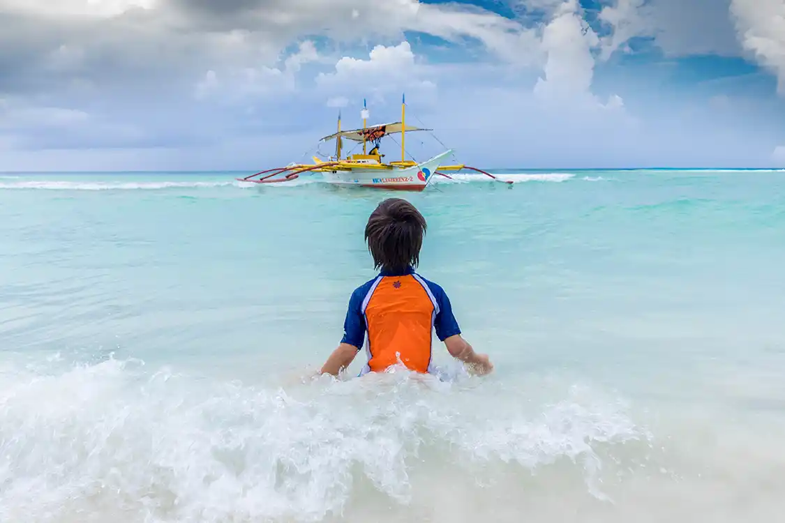 Young boy swimming at Diniwid Beach in Boracay