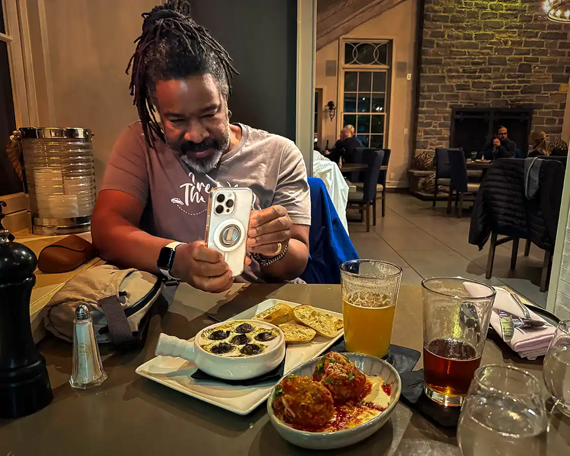 Christopher Rudder taking photos of the appetizers at Riva Restaurant in Gananoque