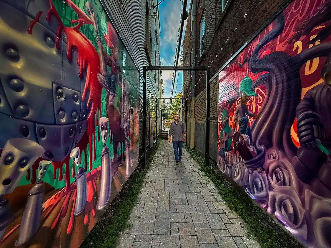 Kevin Wagar walks through an art-filled alley in Gananoque